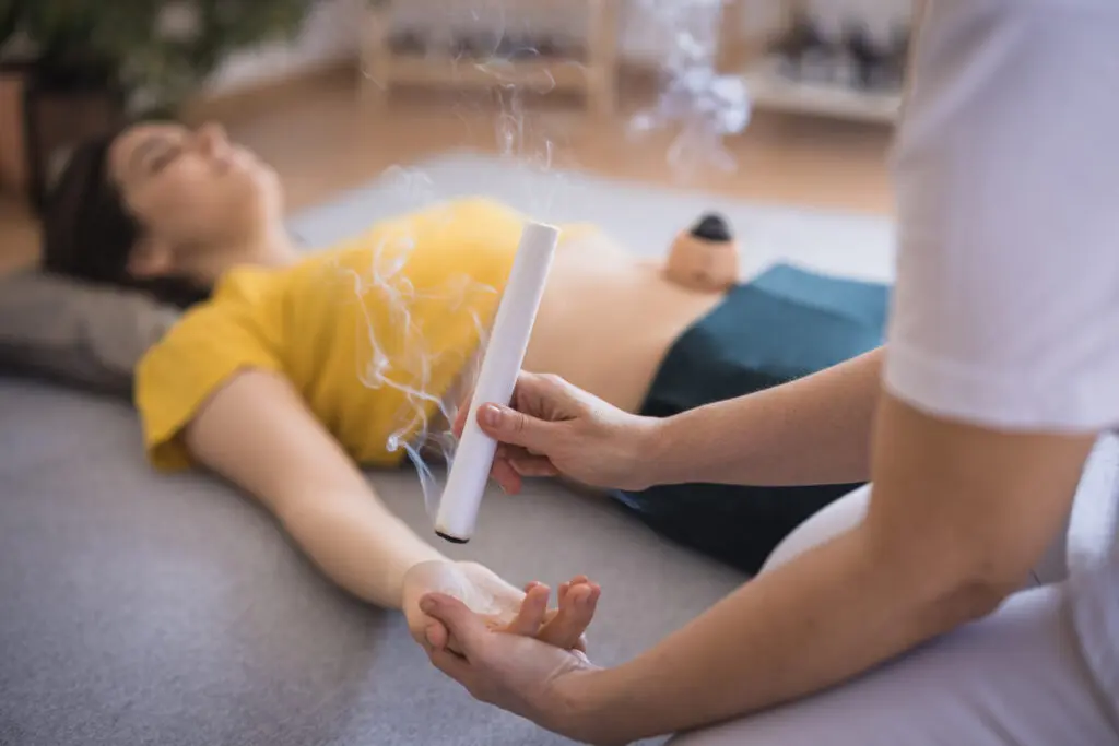 A person using a pregnancy test with another person lying down nearby.